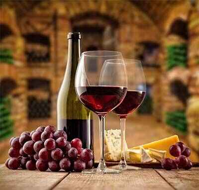 2 glasses of wine with a bottle of wine and fruit